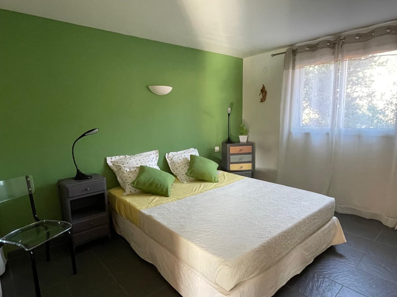 La chambre verte côté fenêtre, ouverte sur le jardin